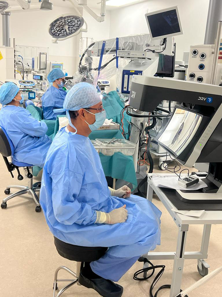 Opthalmologists in blue gowns co-observation with DRV in operating room